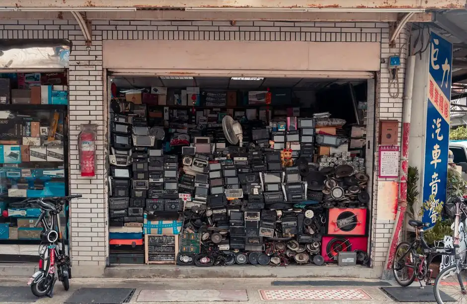 A cluttered street shop displaying vintage radios and electronics, creating a nostalgic urban scene.
